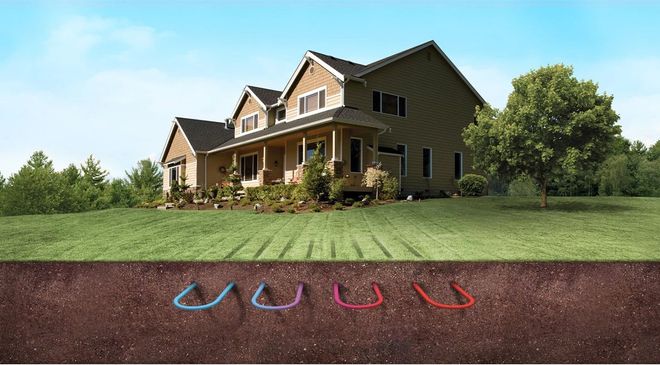 House with underground colored pipes for a geothermal heating system, shown in a lawn.