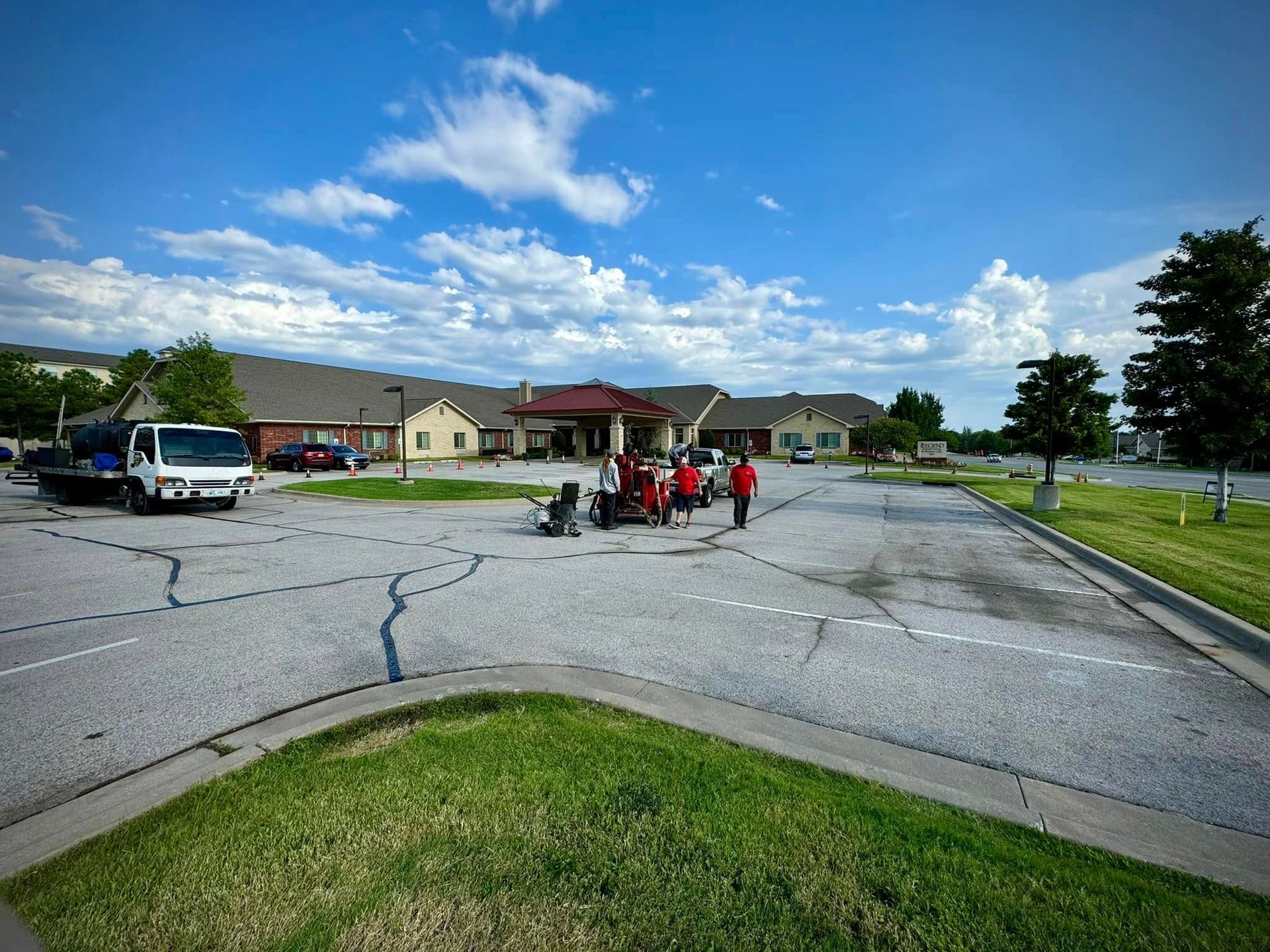 People and red carts on a cracked suburban street under a bright blue sky
