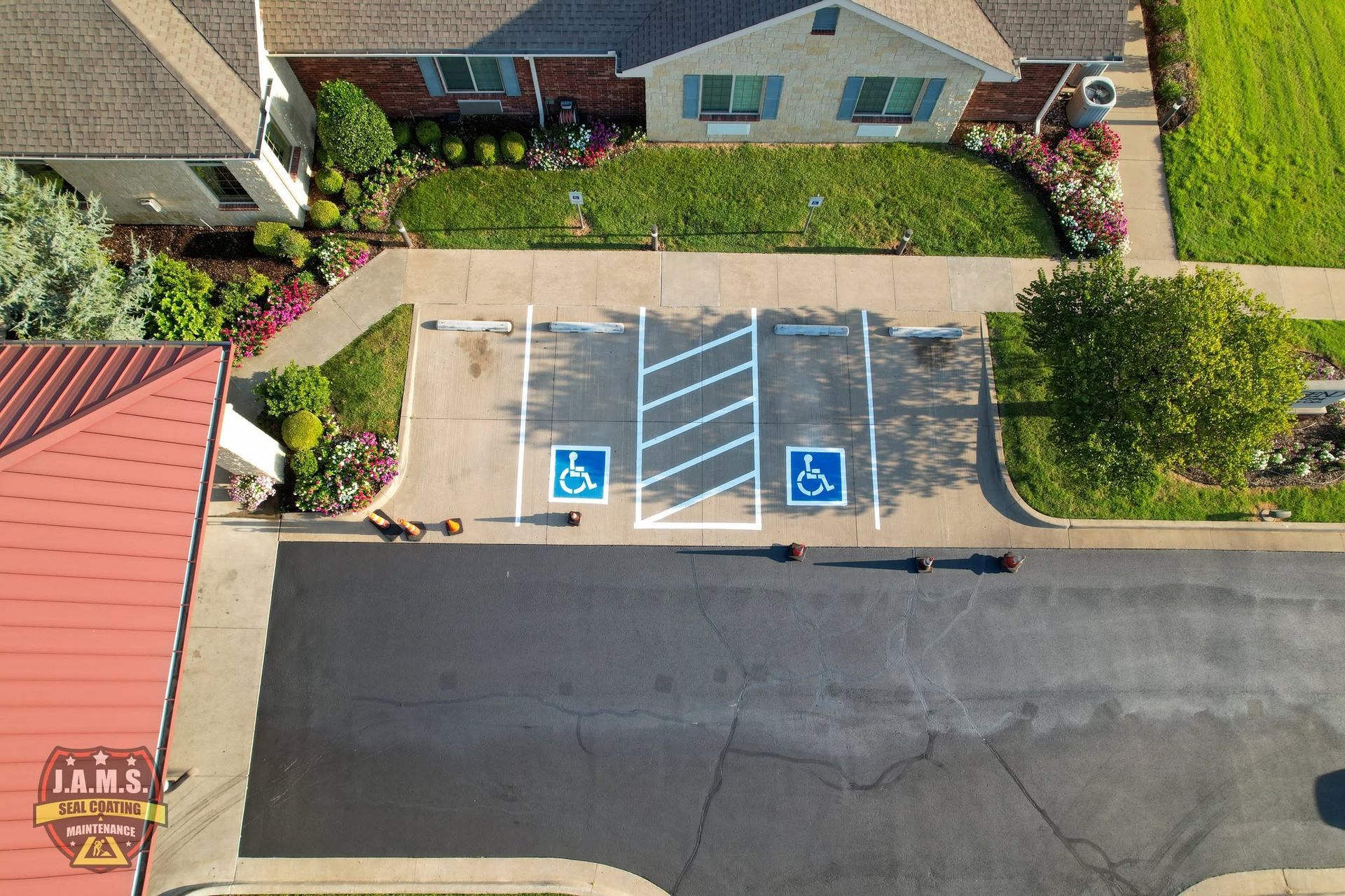 Aerial view of two accessible parking spaces beside a sidewalk and road in a residential area.