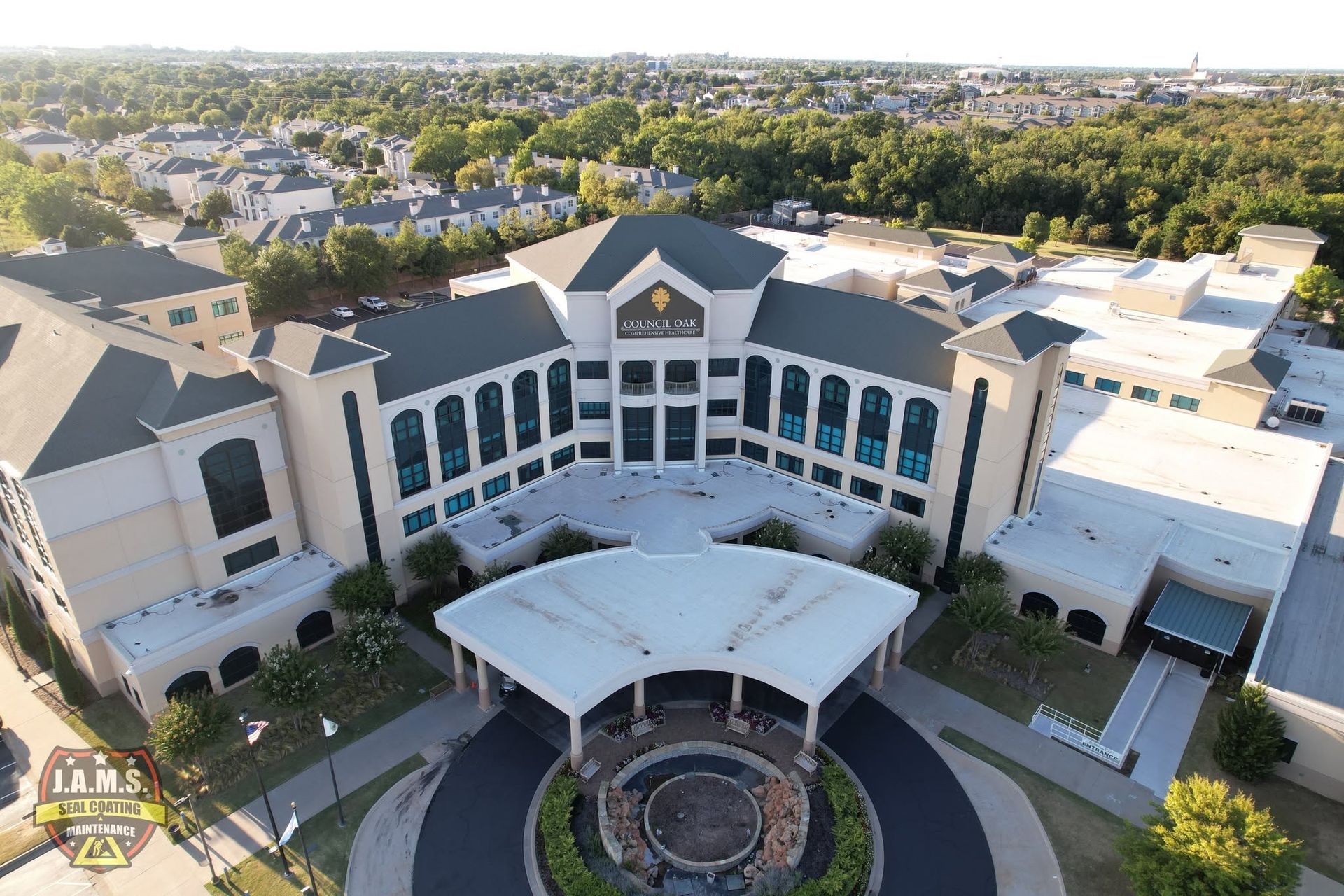 Aerial view of a large modern building with a circular entrance and landscaped courtyard.