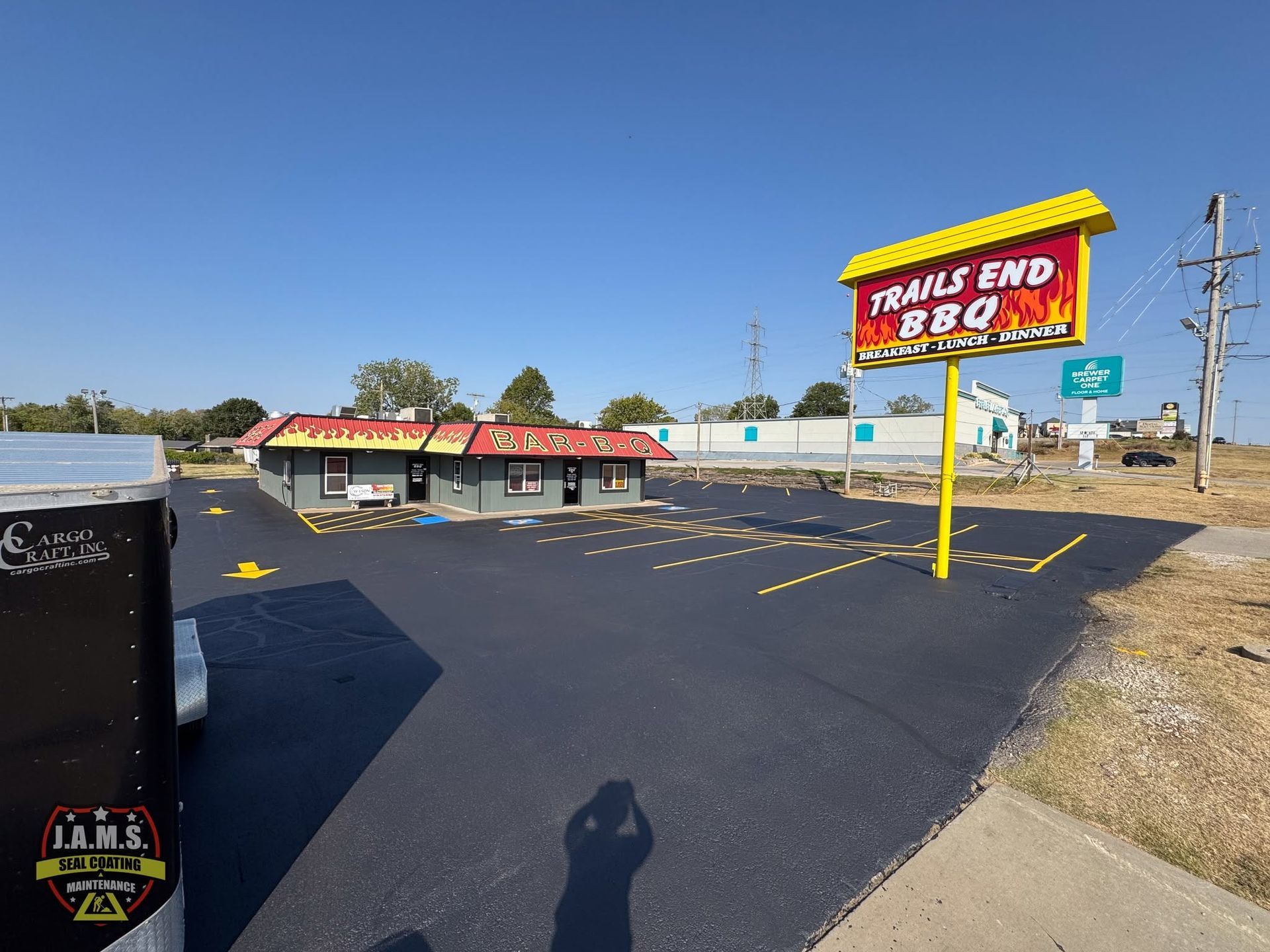 Trav’s End restaurant and parking lot on a sunny day, with a large roadside sign.
