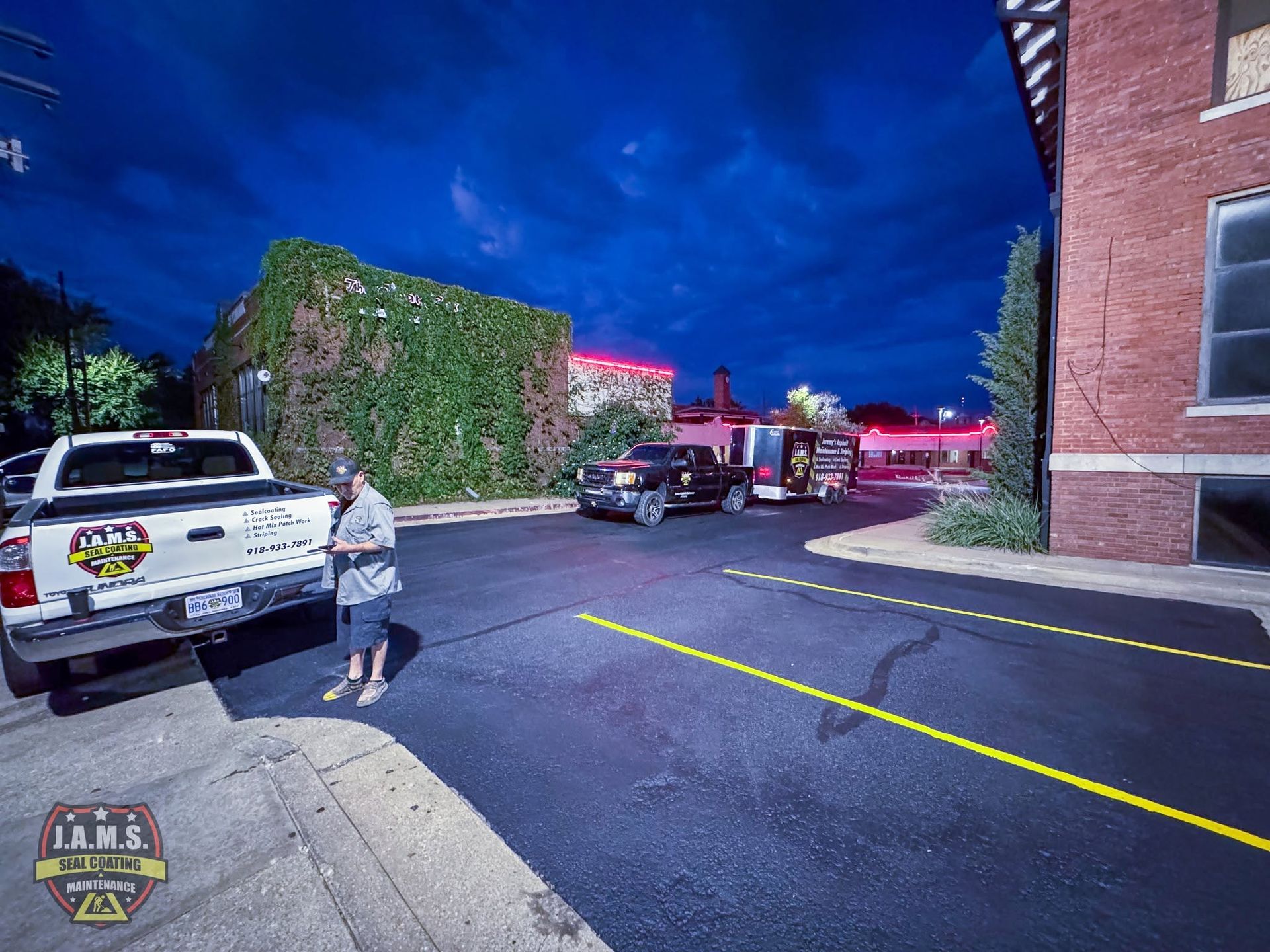 Night scene outside a brick building with parked cars, a child on the sidewalk, and yellow caution tape across the lot