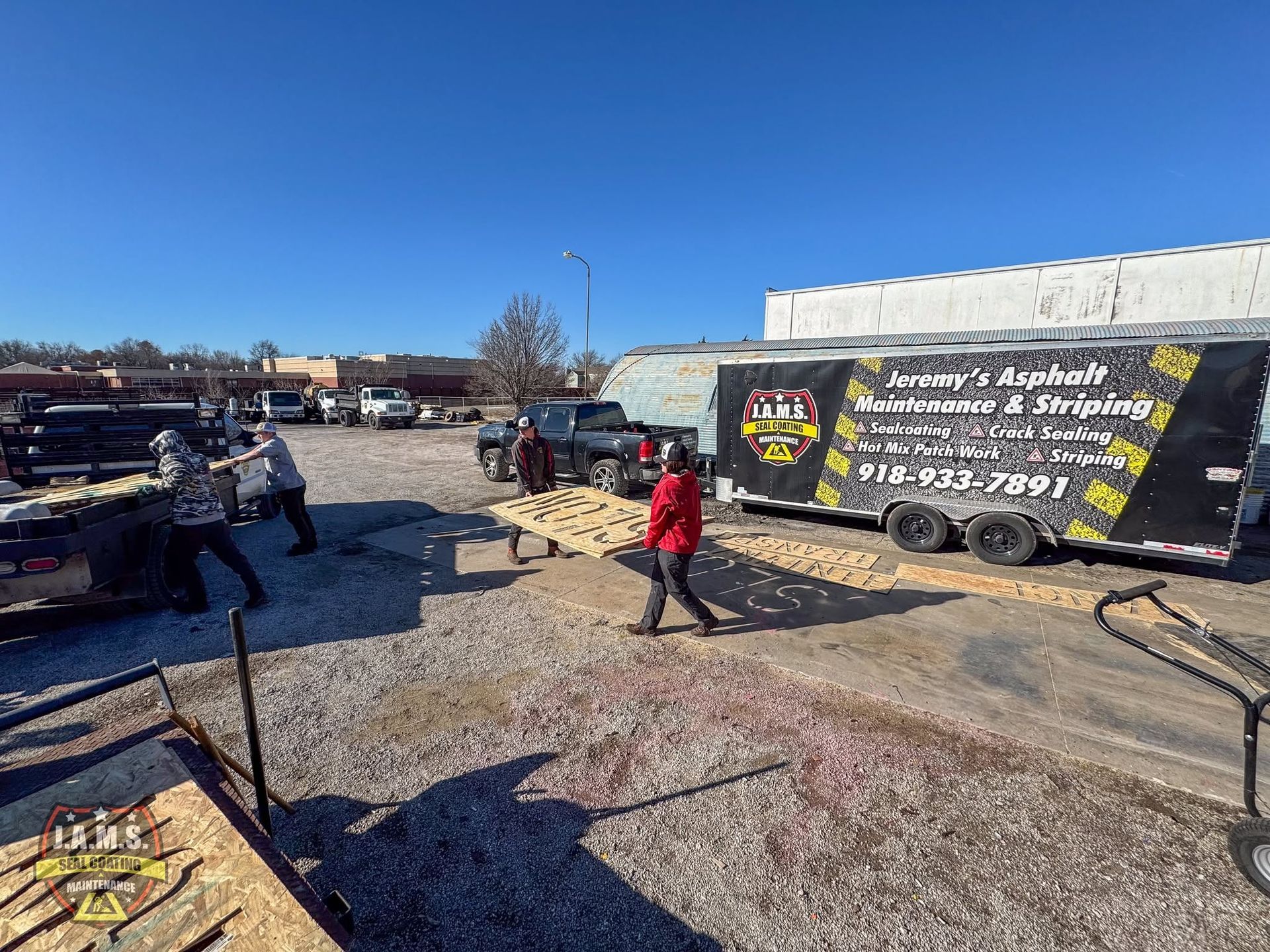 People standing beside a black-and-white food truck in a sunny parking lot
