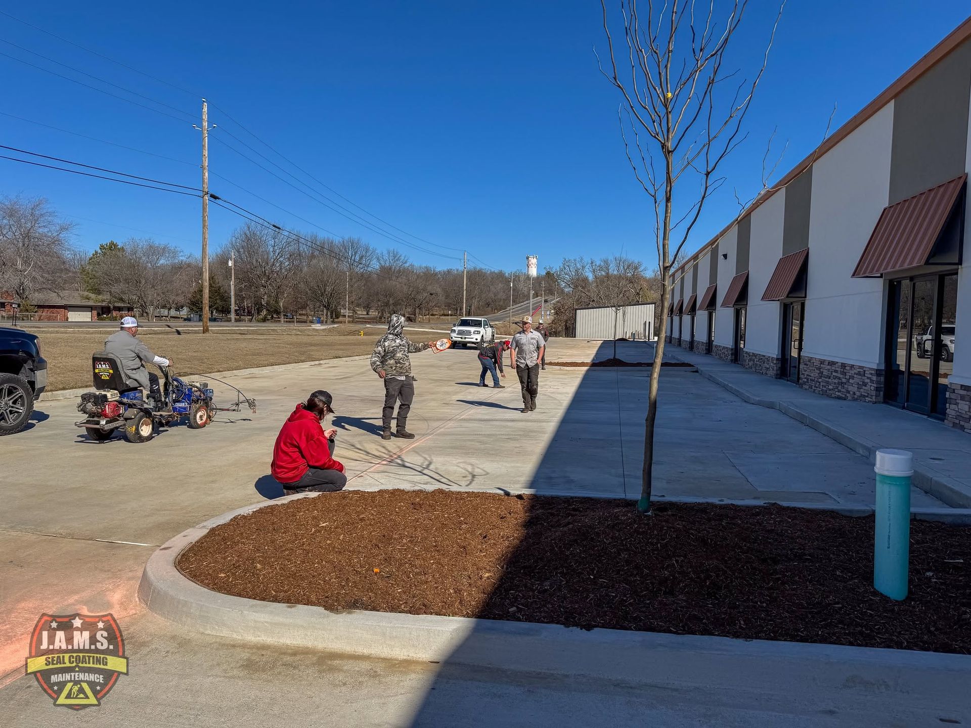 People planting trees beside a storefront on a sunny day