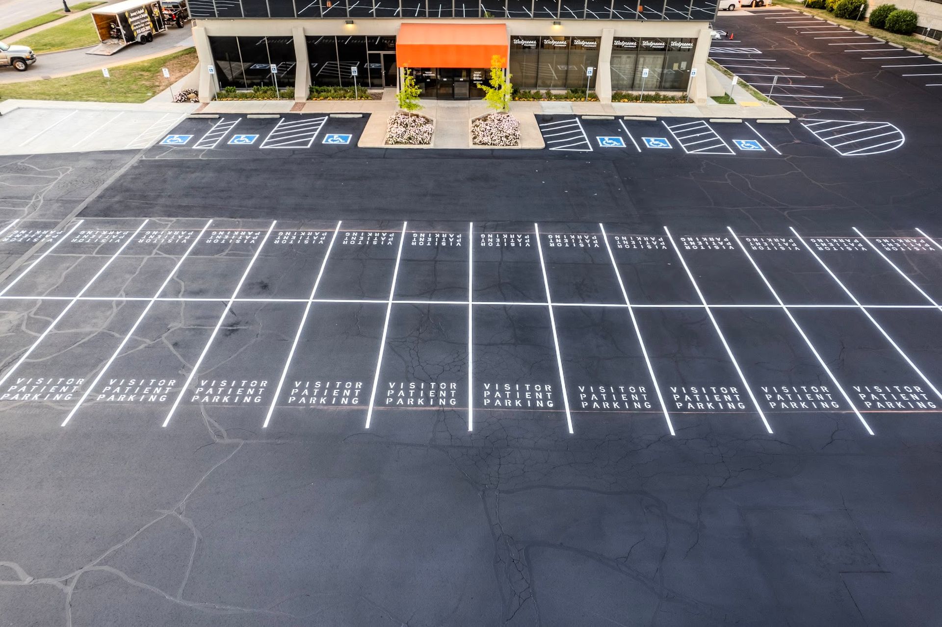 Empty parking lot with painted accessible spaces in front of a building
