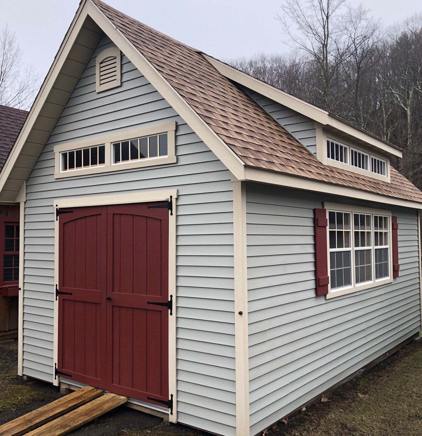 Blue shed with red doors and trim; brown roof.