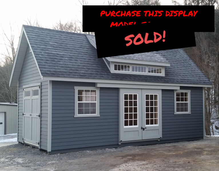 Gray shed with a sold banner.