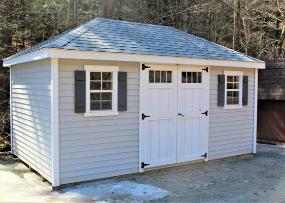Light grey shed with white trim, doors, and shutters, grey roof.