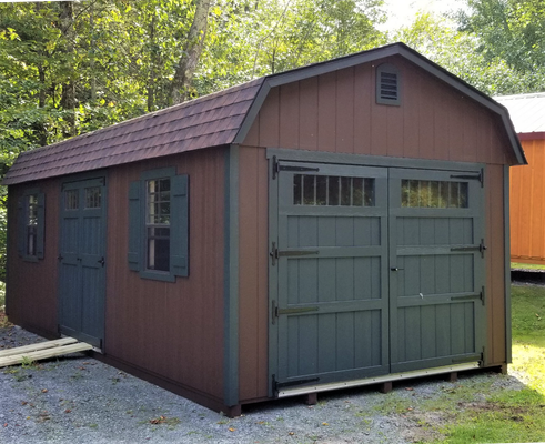Brown and green barn-style shed with double doors and windows.