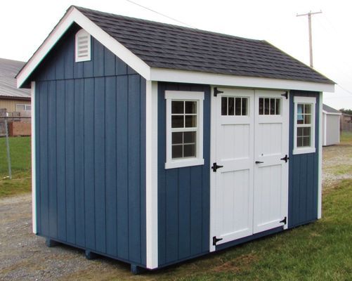 Blue and white shed with black roof, two doors, and two windows on a grassy lawn.