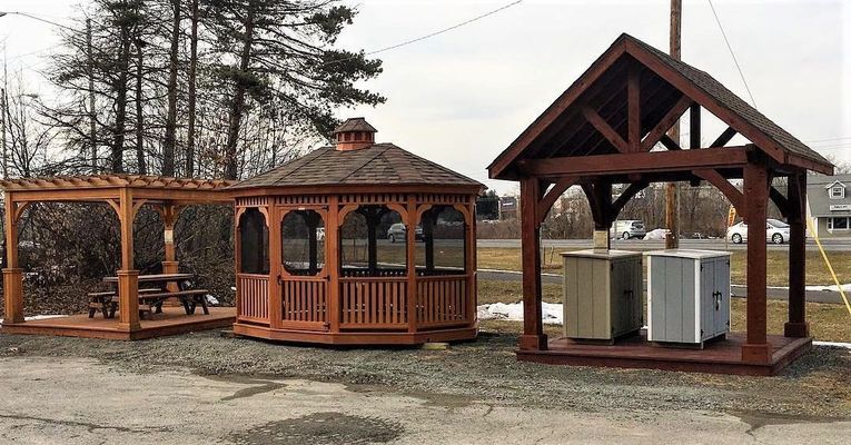 Three wooden outdoor structures: pergola, gazebo, and shed-like cover with hot tub.
