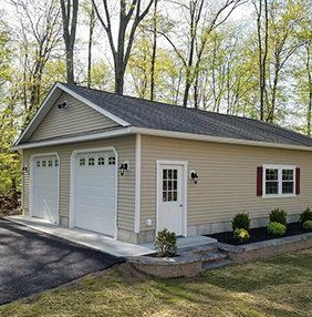 Tan garage with two doors, a white door, and a window with red shutters.