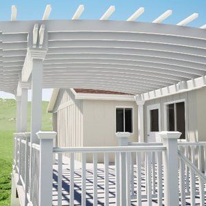 White pergola over a deck with a house in the background.