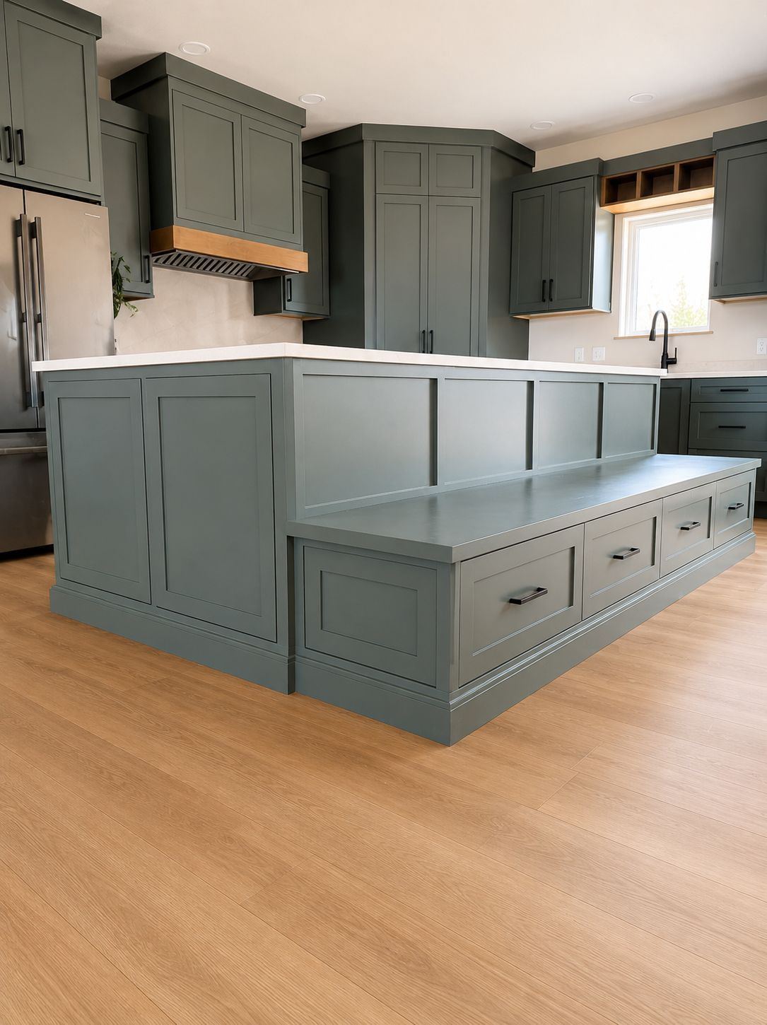 Blue-gray kitchen with large island, cabinets, and light wood floor