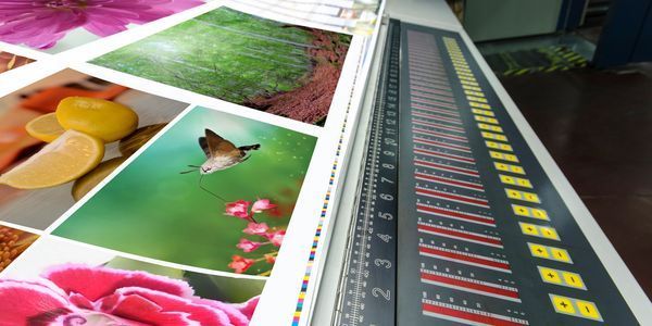 Person operating a black vinyl cutting machine with yellow material.