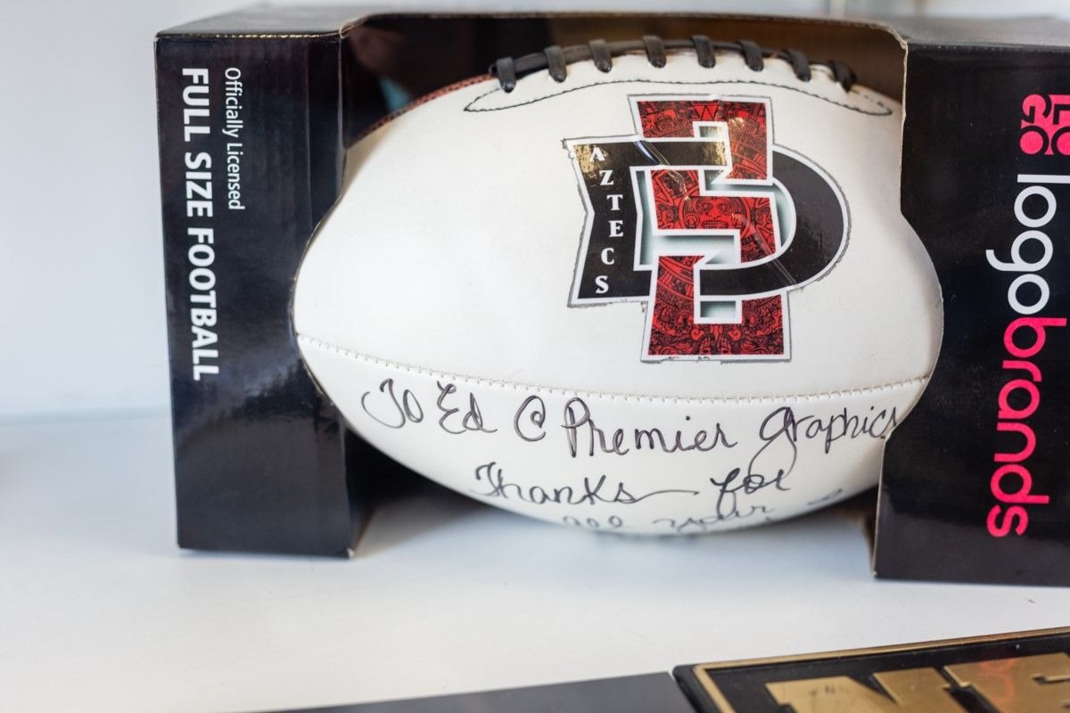 White San Diego State Aztecs football in a LogosBrands box with a handwritten inscription.