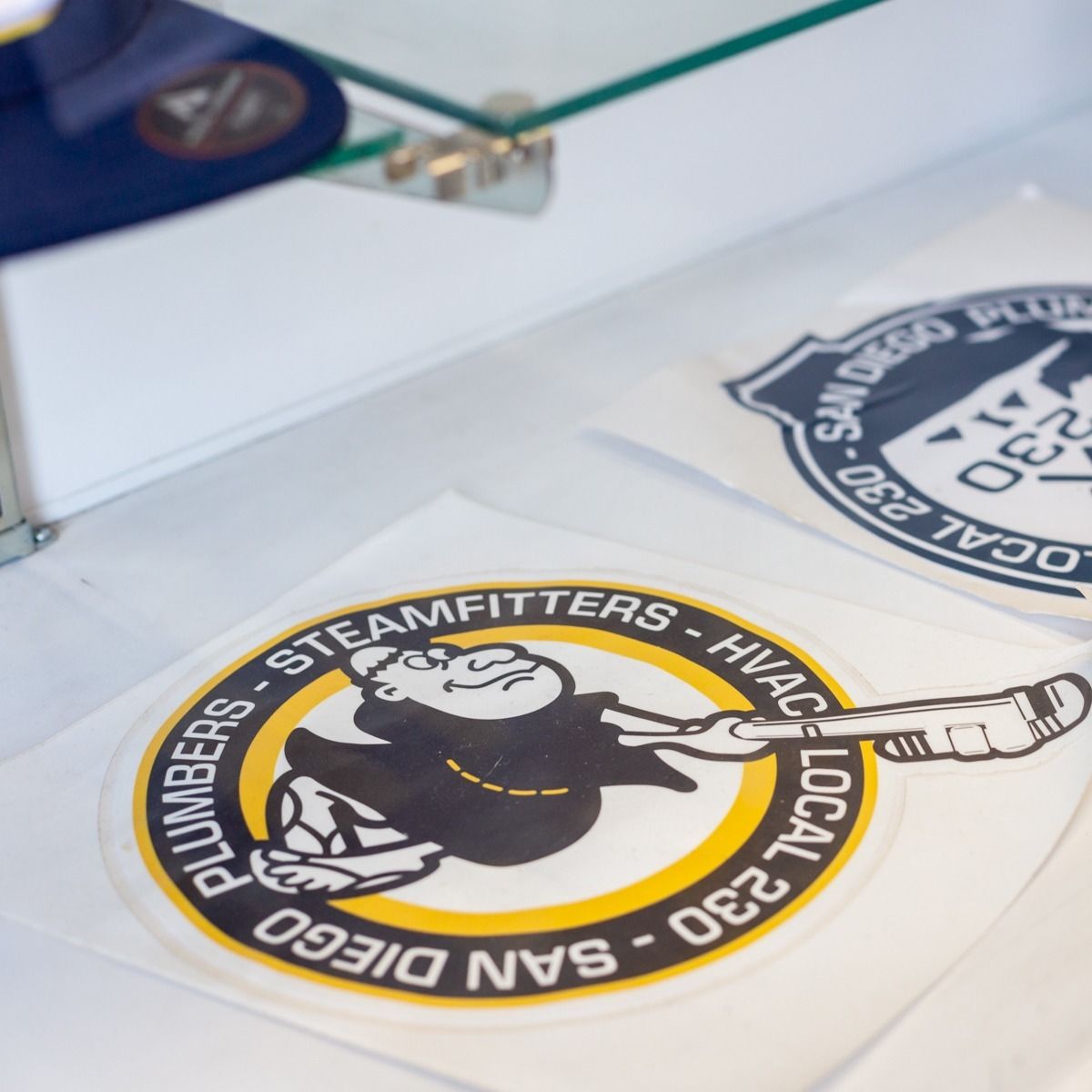 Two stickers: one circular with a monkey holding a wrench and text, the other circular with text and a stylized bear.