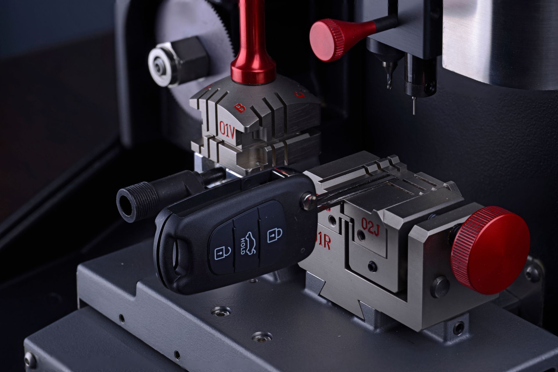 A car key is being cut on a machine.