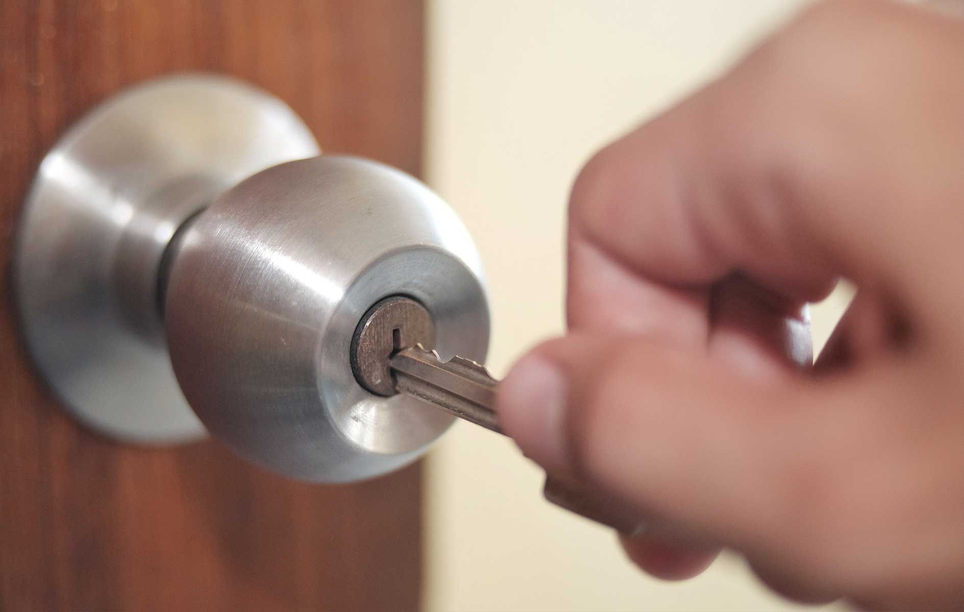 A person is locking a door with a key.