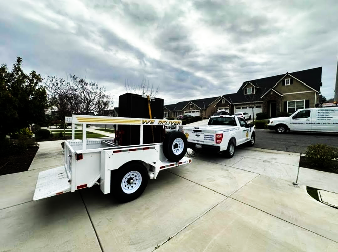 A trailer is being towed by a truck in a driveway.