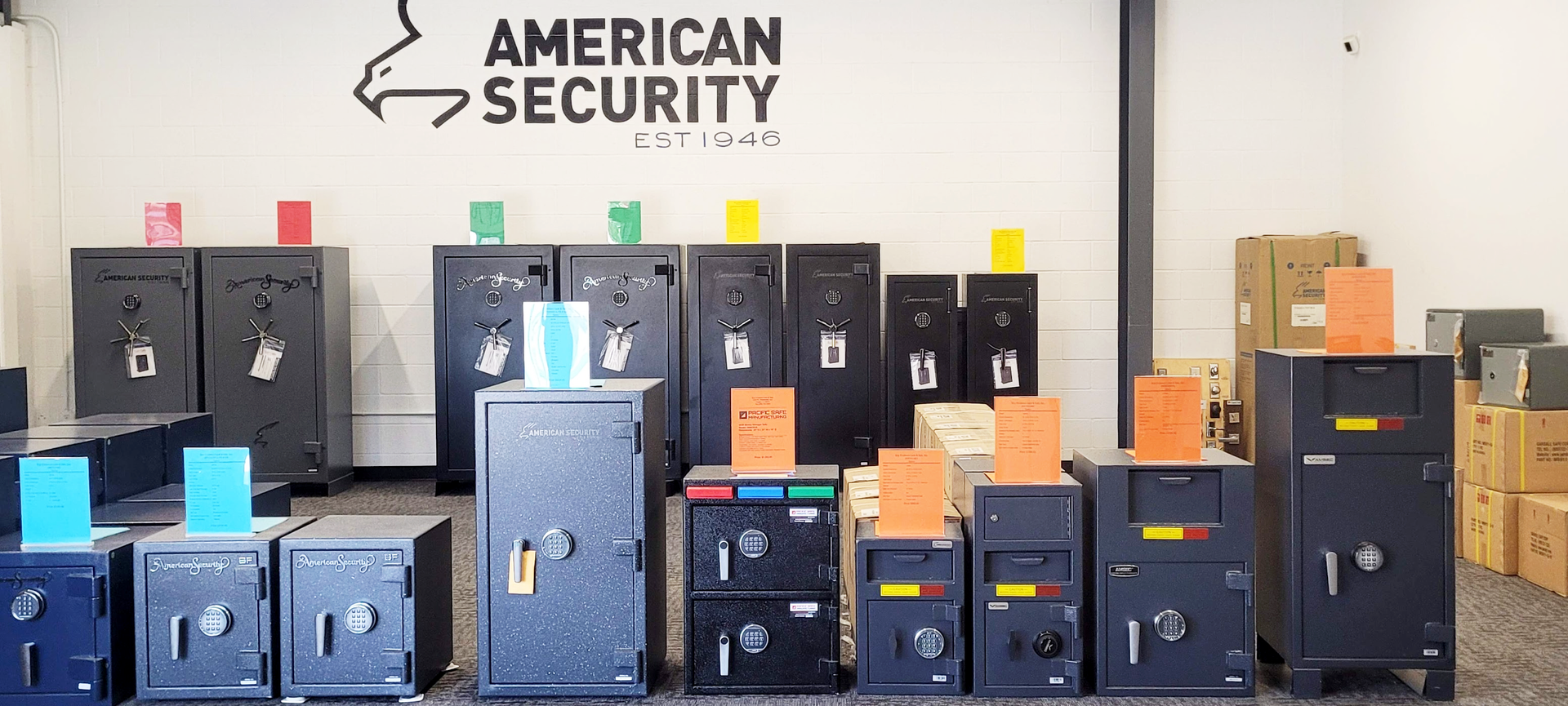 A bunch of safes are lined up in front of a sign that says american security