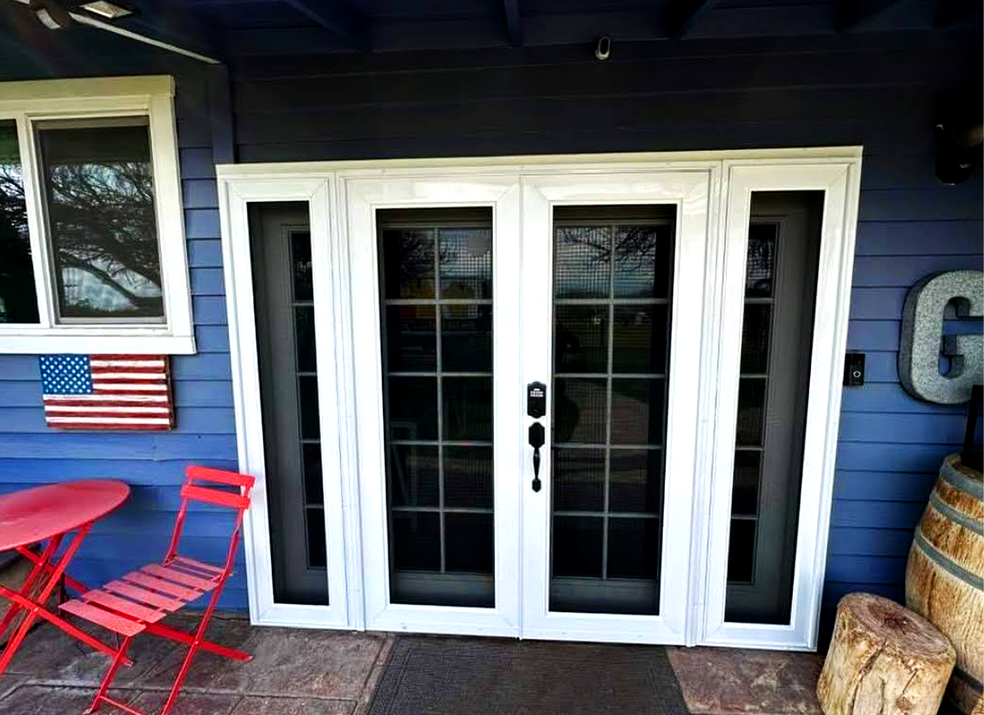 A bedroom with a bed , chair , table and french doors.