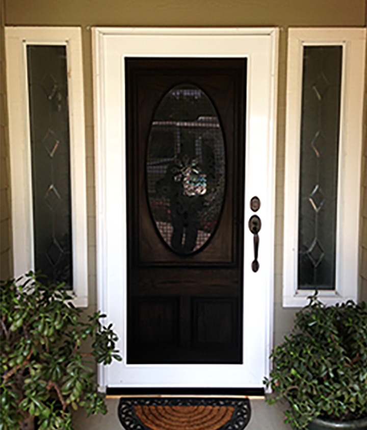 A white door with a sliding glass door is on a porch with plants.