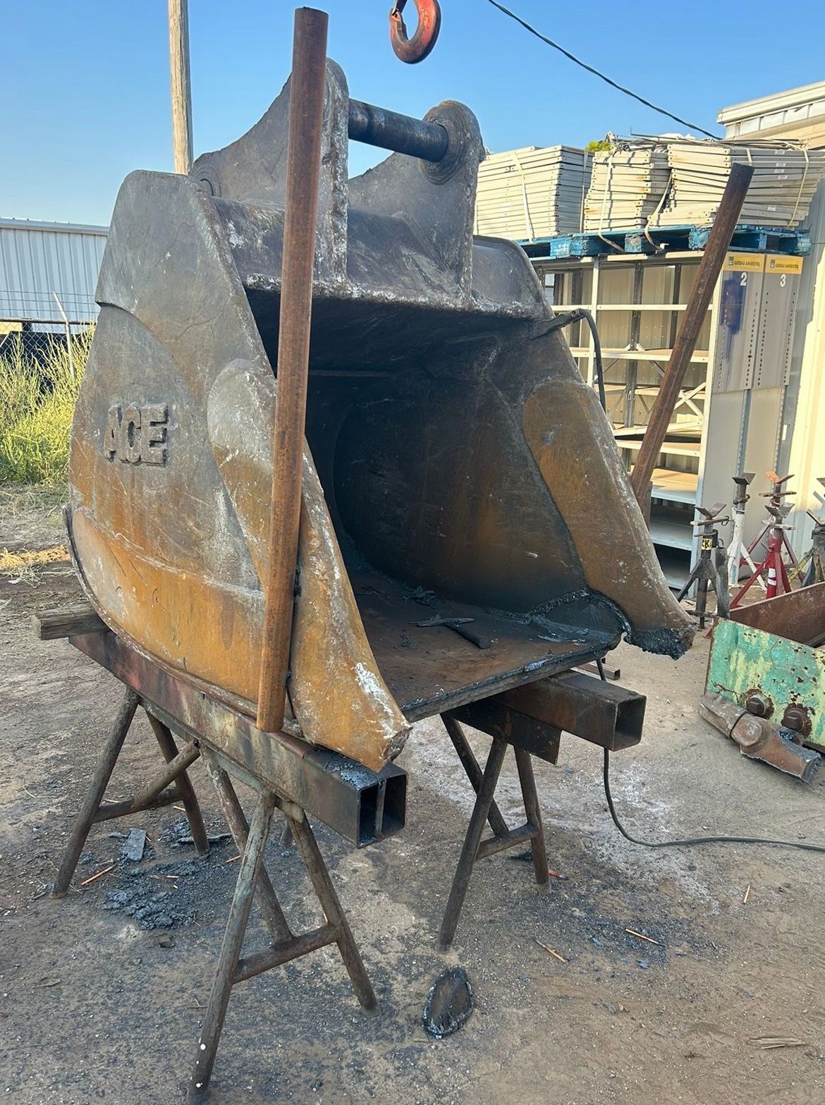 Large, rusty excavator bucket on sawhorses