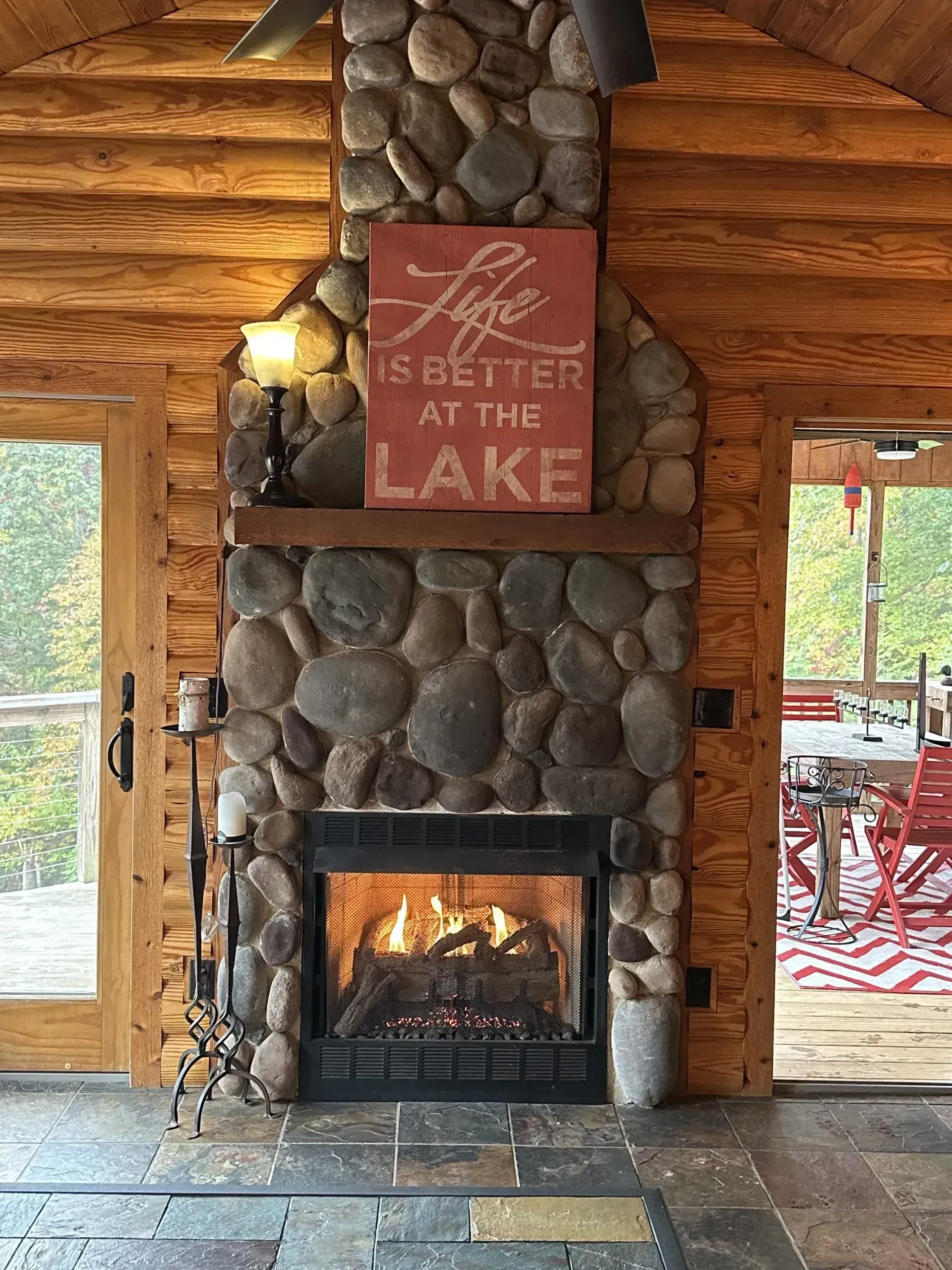 Fireplace with stone facade, fire burning, wooden beams, sign reading 