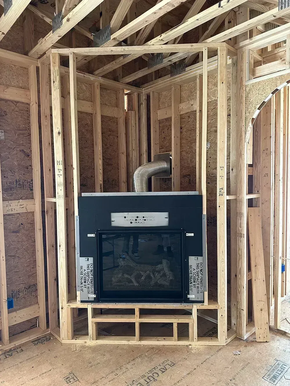 Fireplace framed in wood studs during construction. Interior view.