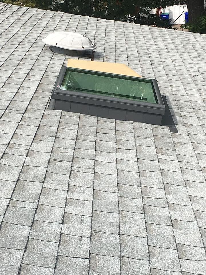 Skylight and dome skylight on a gray shingled roof.