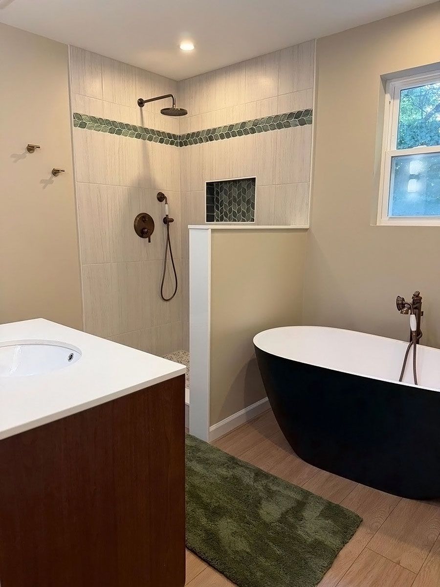 Modern bathroom with freestanding black tub, walk-in shower, and wood vanity
