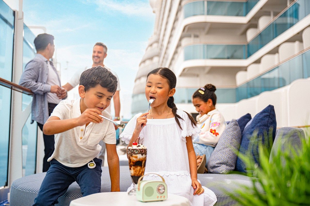 A group of children are eating ice cream on a cruise ship.