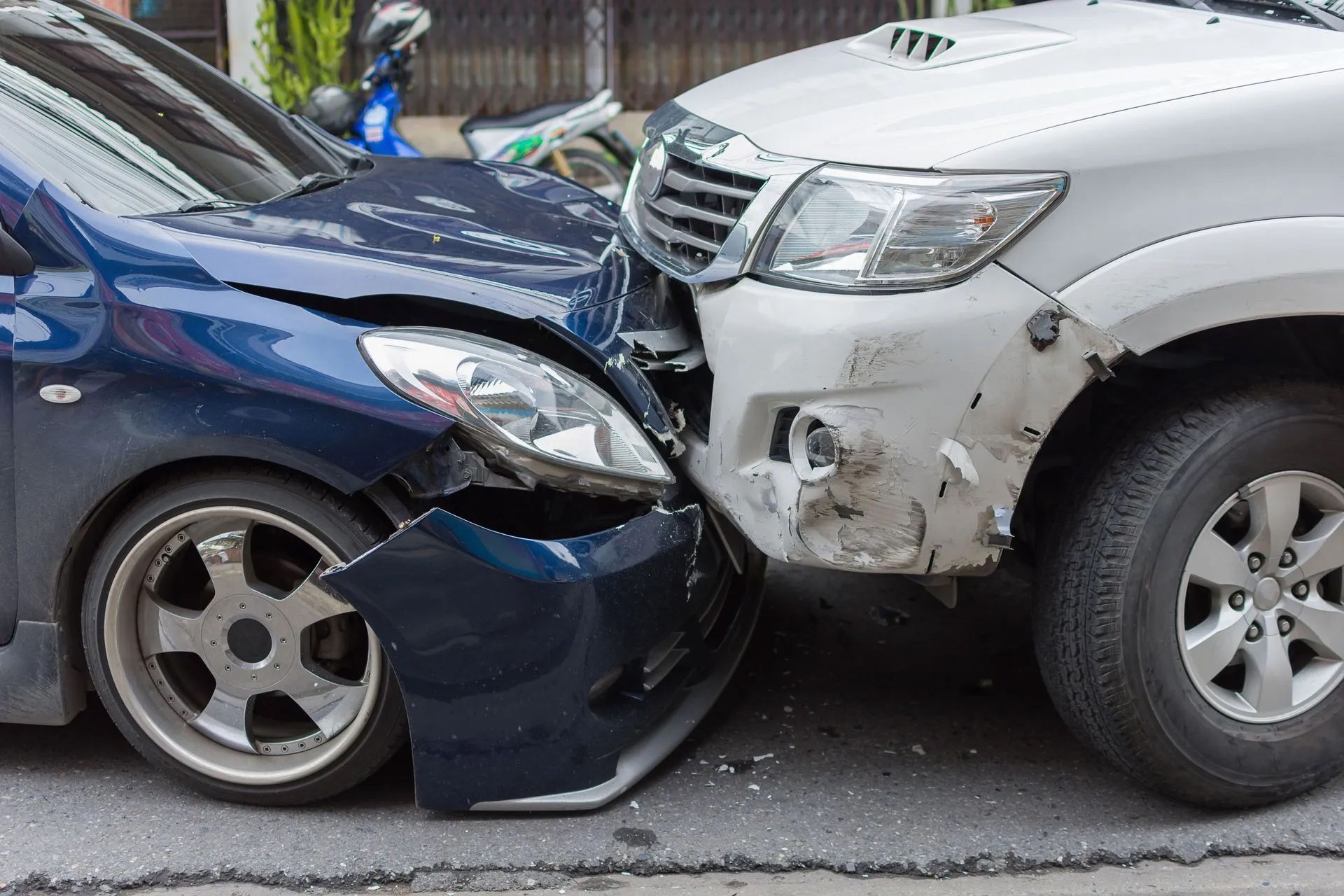 A blue car and a white truck are involved in a car accident.