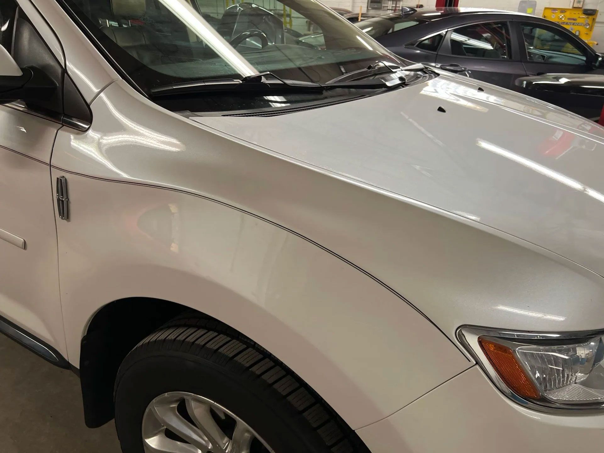 White Lincoln car front quarter panel with black pinstripes and a headlight.