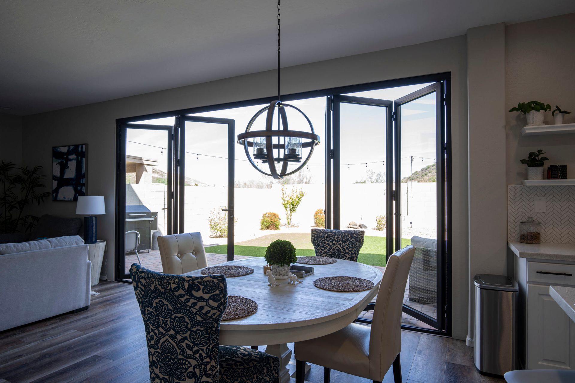 Dining room with round table, chairs, and large folding glass doors to the backyard.
