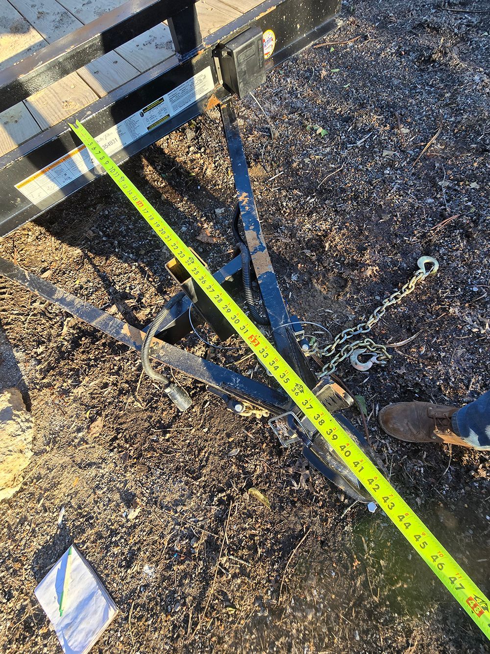 Construction worksite with a bright yellow tape measure stretched across dirt and tools.