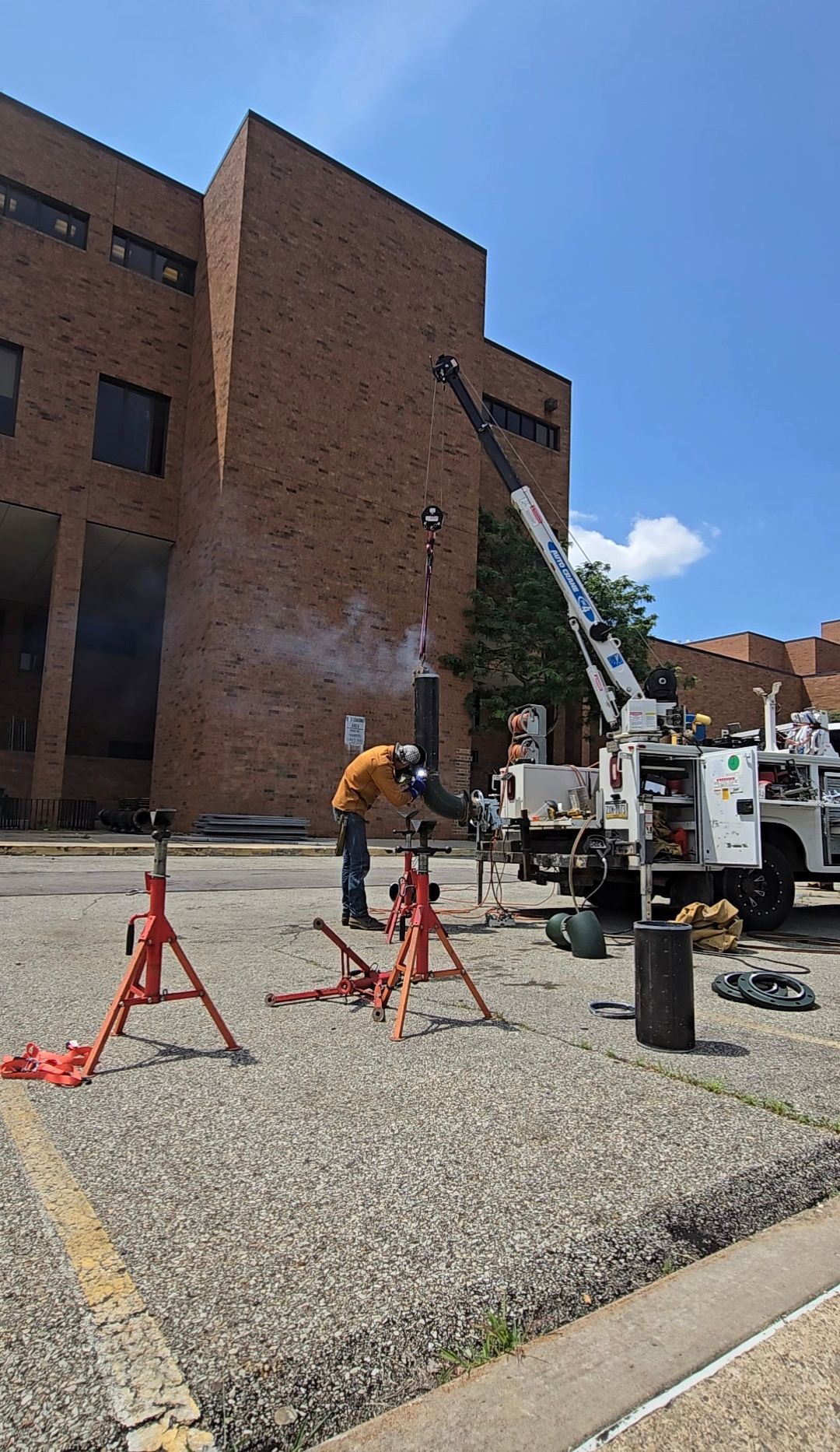 Crane lifting a metal pipe