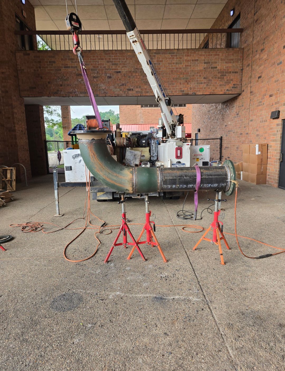 Industrial pipe rigging setup in a brick warehouse