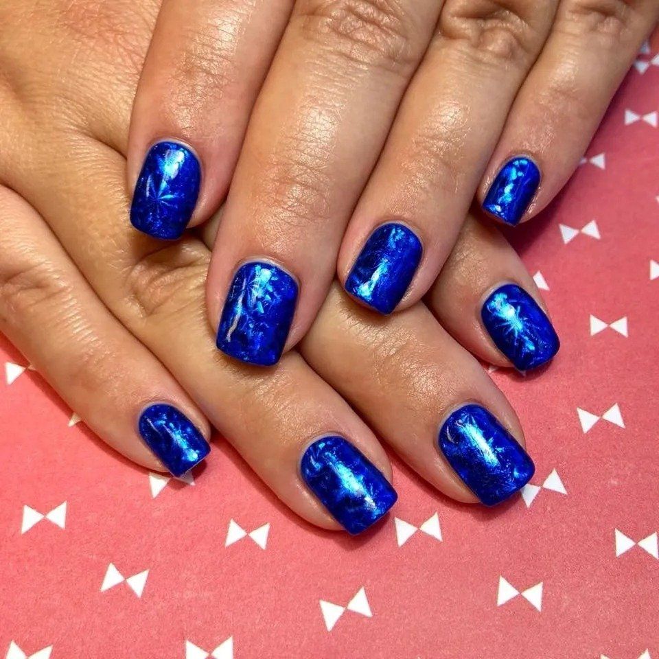 A close up of a woman 's nails with blue nail polish