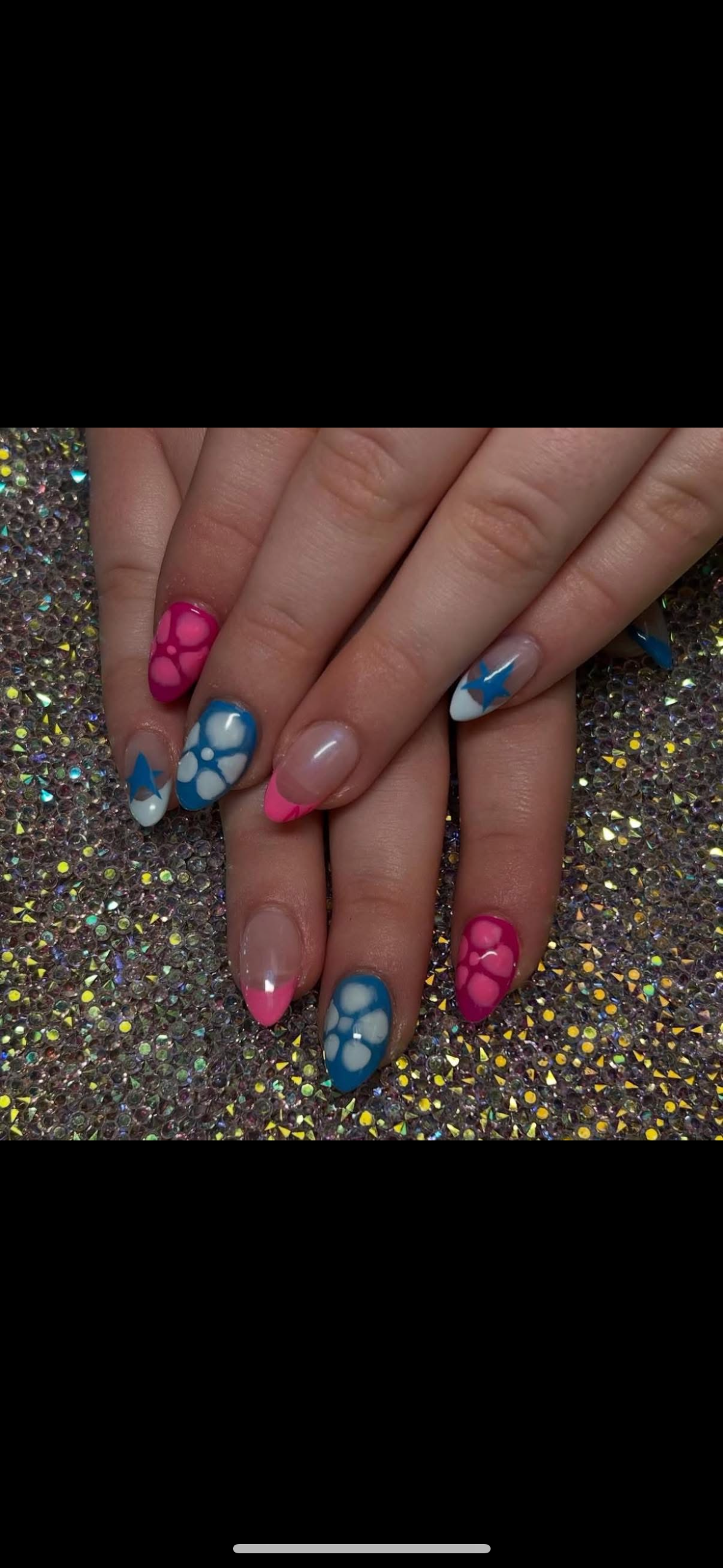 A close up of a person 's nails with a pink and blue design.
