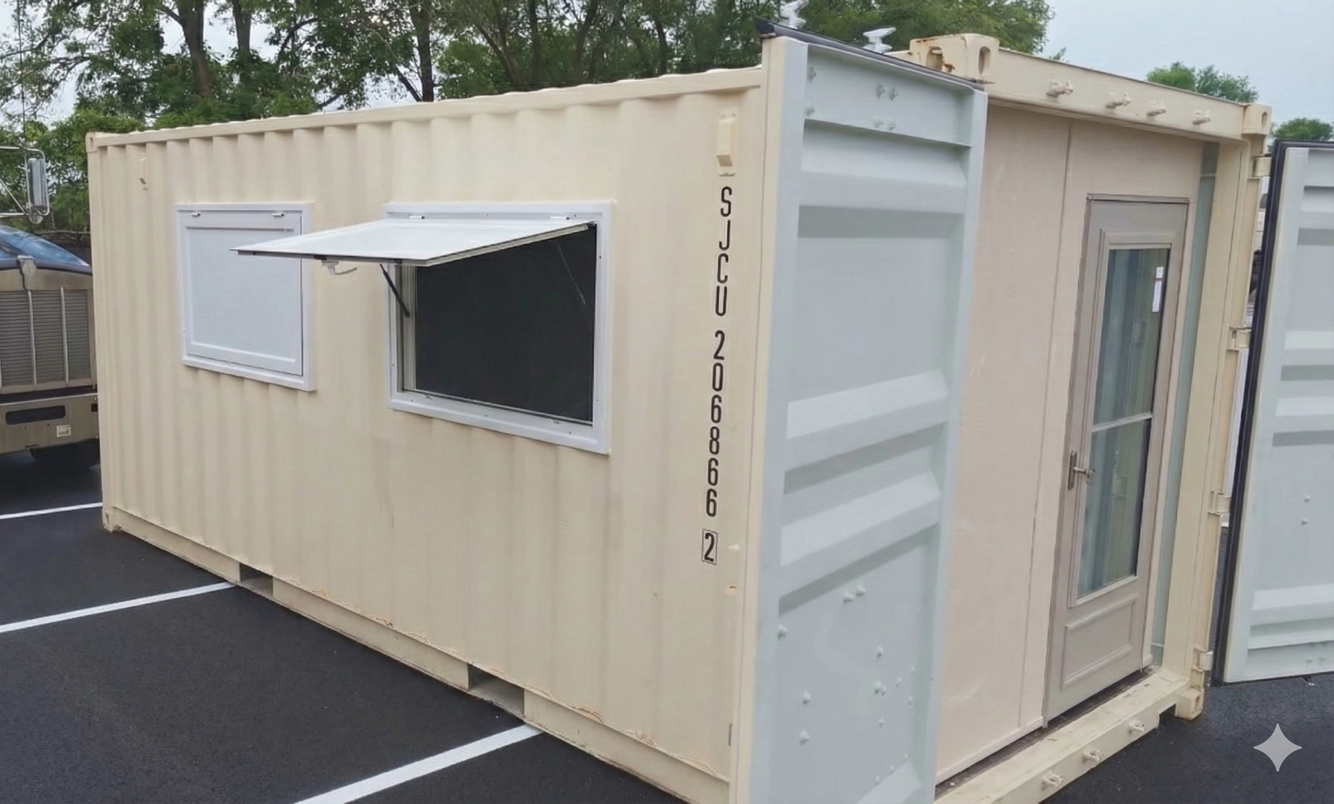 Beige shipping container converted into an office with a window, door, and open awning.