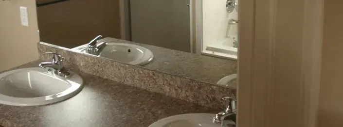 Bathroom with two sinks, mirror, and a shower stall.