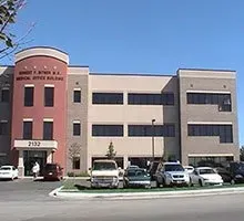 Medical office building exterior with parked cars.