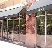 Forever 21 store entrance with glass windows, black awnings, and brick accents.