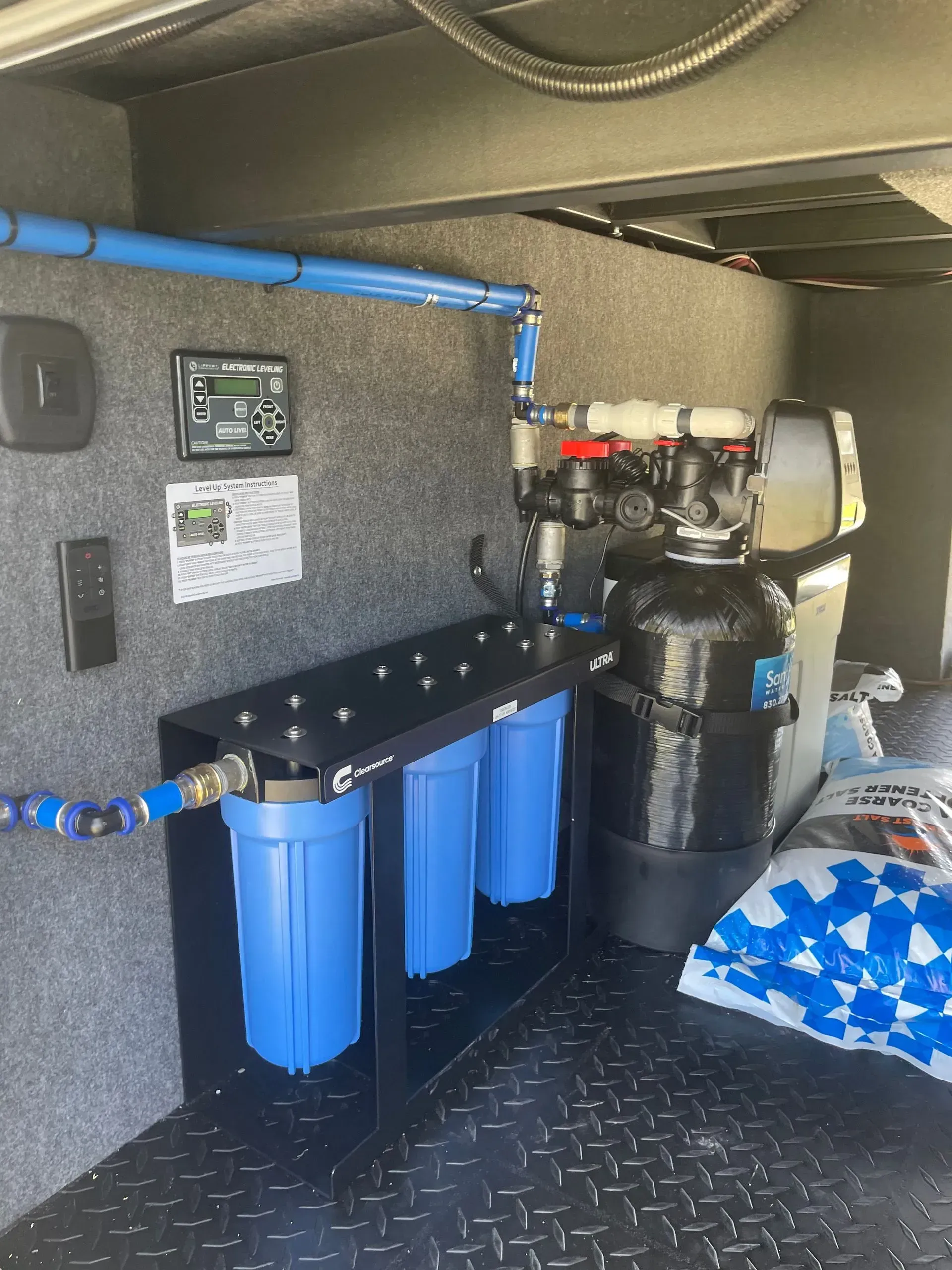 RV water filtration system with blue filters and a water softener.