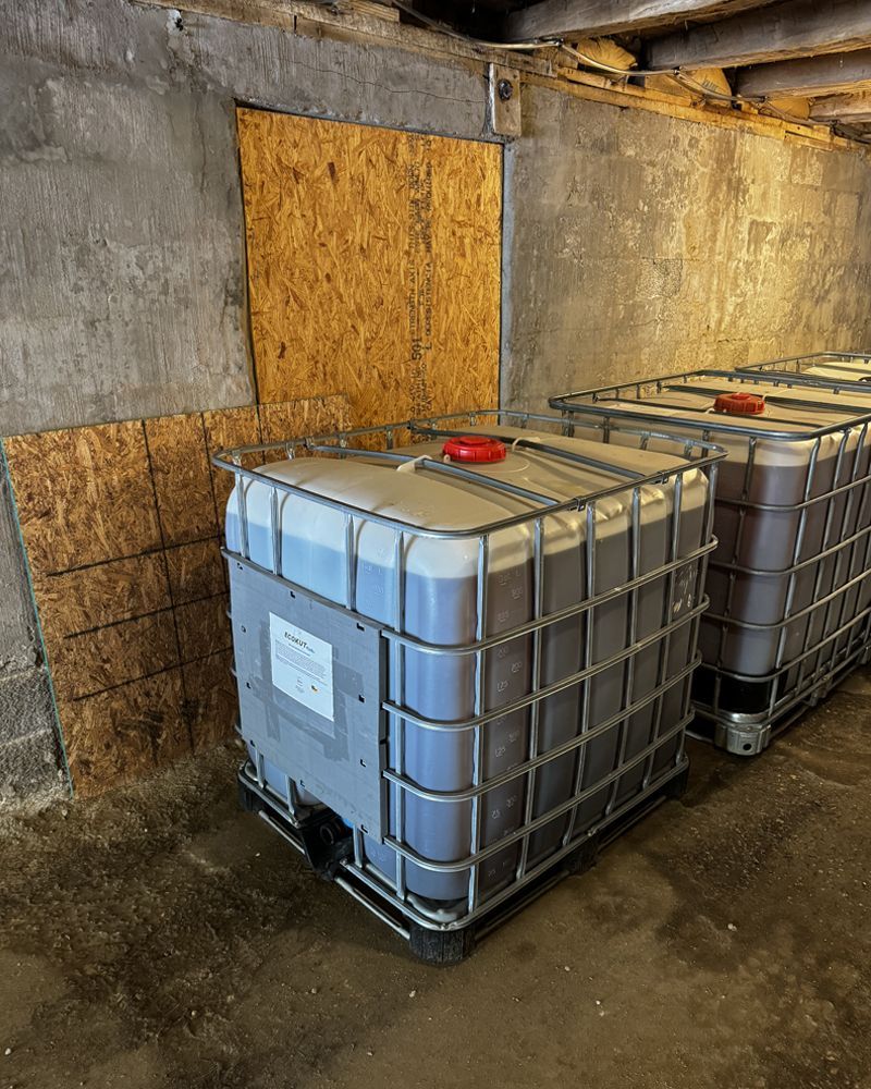 Two large plastic containers are sitting next to each other in a warehouse.