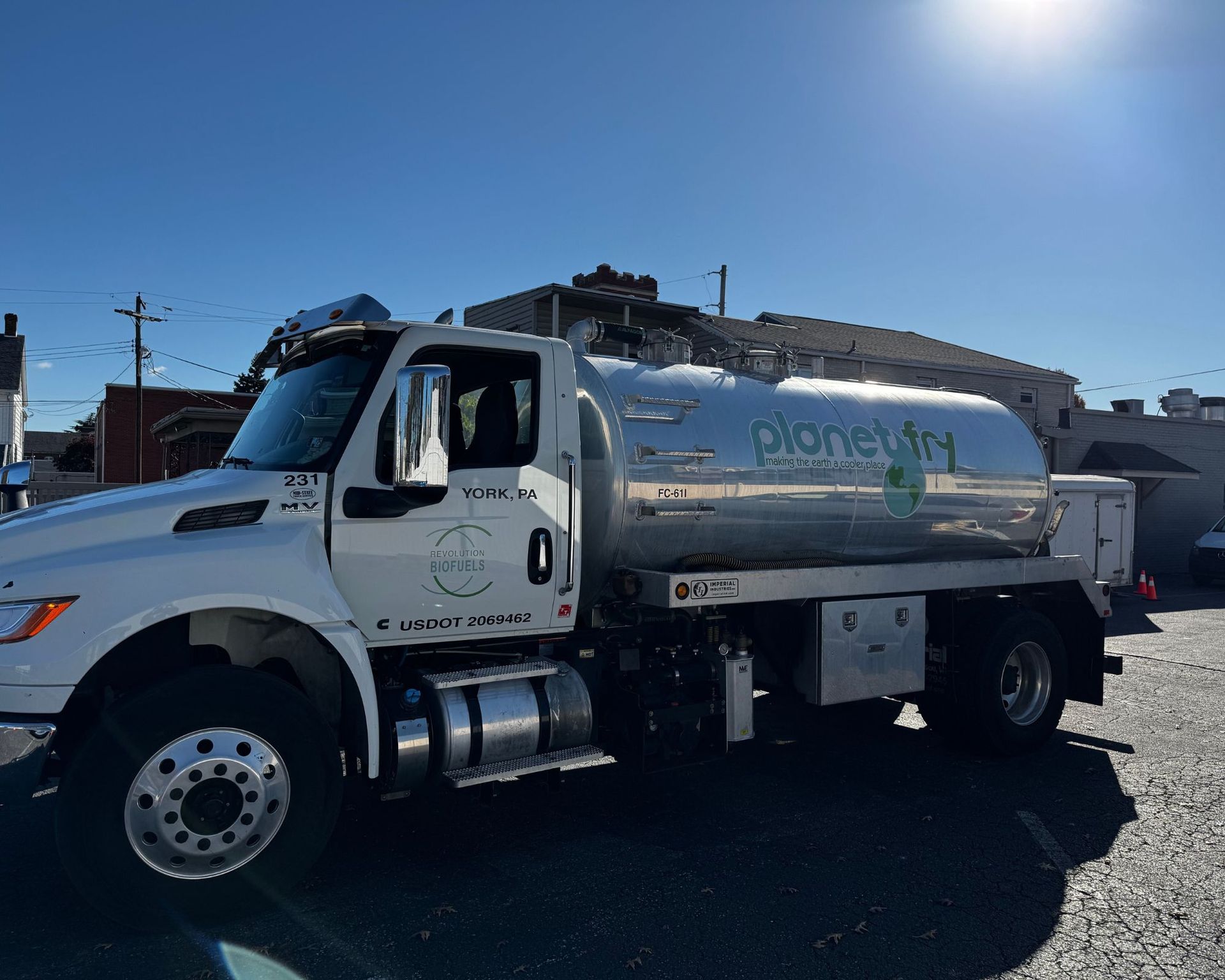 A white tanker truck is parked in a parking lot.