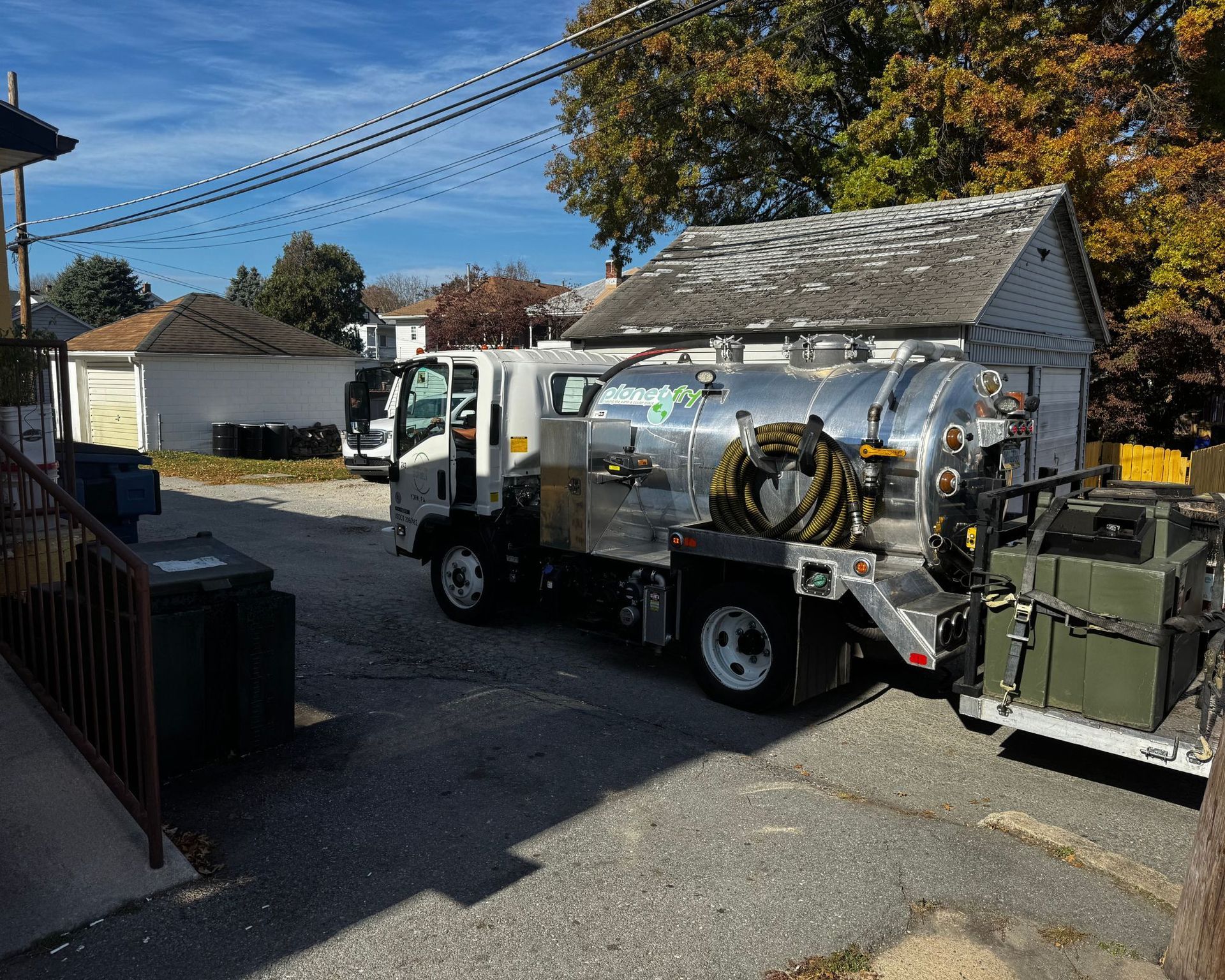 A vacuum truck is parked in front of a house.