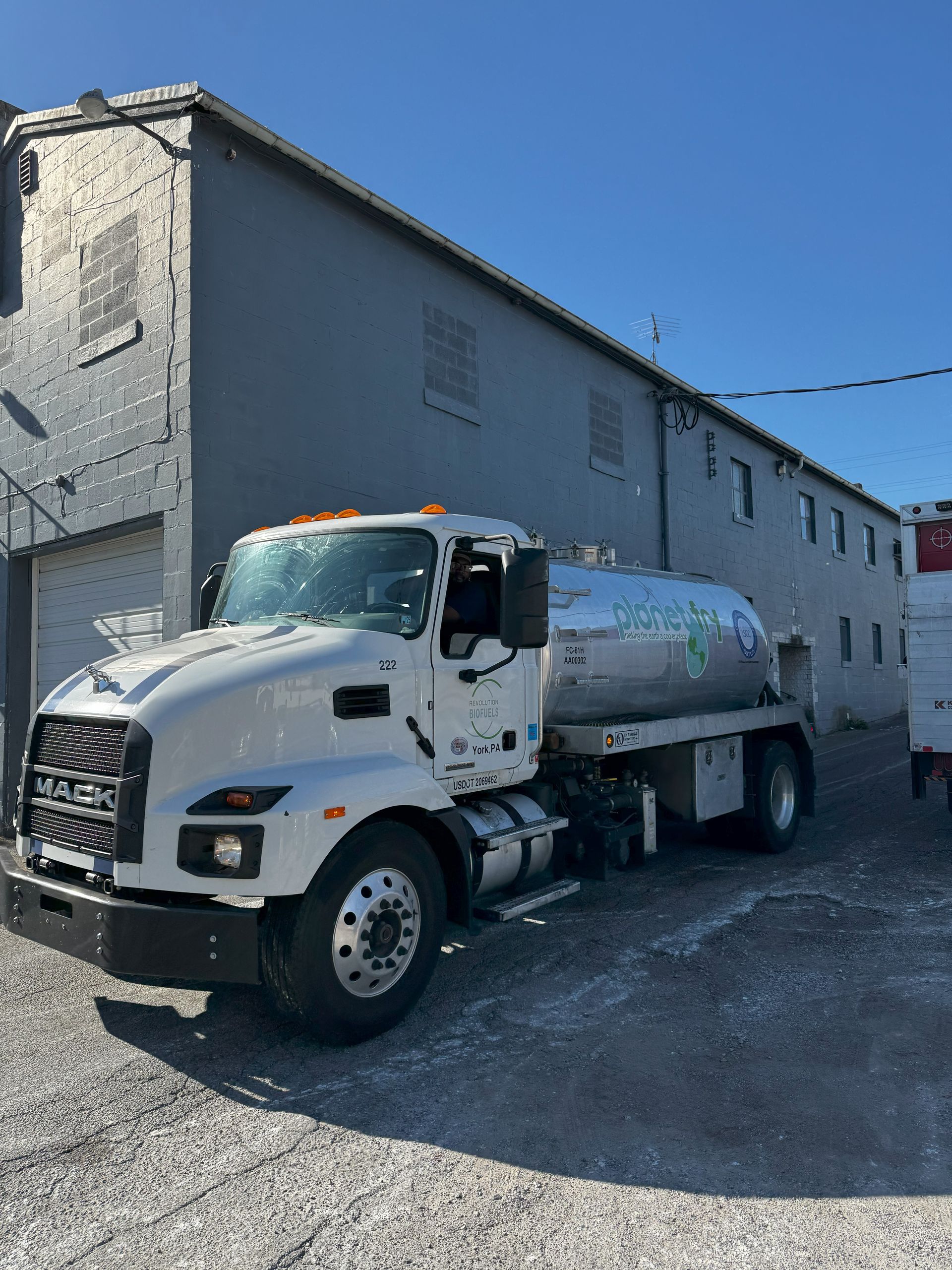 A white truck is parked in front of a building.